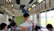 An organising staff member holds a cat in a train cat cafe, held on a local train to bring awareness to the culling of stray cats, in Ogaki, Gifu Prefecture, Japan September 10, 2017. REUTERS/Kim Kyung-Hoon