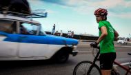 A member of the VeloCuba bicycle repair and rental agency avoids traffic during an urban bicycle tour in Havana, on September 5, 2017. AFP / Adalberto Roque