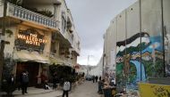 People stand outside the Walled Off hotel, which was opened by street artist Banksy in the West Bank city of Bethlehem, March 3, 2017 (REUTERS / Ammar Awad) 