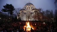 Serbian Orthodox believers burn dried oak branches, which symbolize the Yule log, on Orthodox Christmas Eve in front of the St. Sava Church in Belgrade, January 6, 2014.  (Reuters) 

