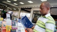 A staff member of the Exclusive Books bookshop at the Gateway Mall in Durban holds the book 