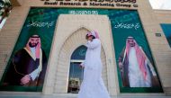 A man speaks on the phone as he walks past posters depicting Saudi Arabia's King Salman bin Abdulaziz Al Saud and Crown Prince Mohammed bin Salman in Riyadh, Saudi Arabia, November 9, 2017. Reuters/Faisal Al Nasser 