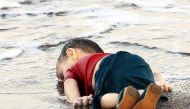 A young migrant, who drowned in a failed attempt to sail to the Greek island of Kos, lies on the shore in the Turkish coastal town of Bodrum, Turkey. Reuters/Nilufer Demir/DHA 