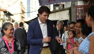 This photo taken on November 12, 2017 shows Canada's Prime Minister Justin Trudeau (C) greeting mothers at a clinic run by the non-governmental organisation Likhaan during a visit on the sidelines of the Association of Southeast Asian Nations (ASEAN) summ