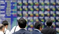 FILE PHOTO: People walk past an electronic stock quotation board outside a brokerage in Tokyo, Japan, September 22, 2017. REUTERS/Toru Hanai/File Photo.