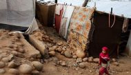 A girl from the Rohingya Muslim community walks past a makeshift settlement on the outskirts of Jammu, May 6, 2017. (Reuters/ Mukesh Gupta) 