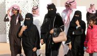 A picture taken on January 19, 2018 shows Saudi women and men walking during the King Abdulaziz Camel Festival in Rumah, some 160 kilometres east of Riyadh. AFP / FAYEZ NURELDINE