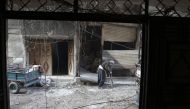 An elderly Syrian man looks for a safe place to take shelter in the rebel-held town of Hamouria in the Eastern Ghouta region on the outskirts of Damascus during bombardment by government forces on March 14, 2018. / AFP / ABDULMONAM EASSA
