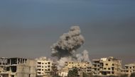 A general view shows smoke billowing in Hazeh, in the rebel enclave of Eastern Ghouta on the outskirts of Damascus on March 15, 2018 during reported shelling by Syrian government forces.  AFP / AMER ALMOHIBANY
