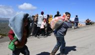 Civilians fleeing the city of Afrin in northern Syria walk at the mountainous road of al-Ahlam while heading towards the check point in az-Ziyarah, in the government-controlled part of the northern Aleppo province, on March 16, 2018.  AFP / George OURFALI