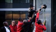 Alain Robert, the French urban climber dubbed Spiderman, is grabbed by security guards preventing him to climb a building hosting the headquarters of French energy giant Engie at La Defense business area, on March in Paris on March 14, 2018. AFP / PHILIPP