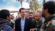 A handout picture released by the official Facebook page of the Syrian Presidency on March 18, 2018, shows Syrian President Bashar al-Assad (C) talking with government troops in Eastern Ghouta