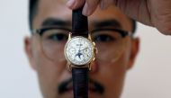 An exhibitor displays the Patek Philippe 18k gold perpetual chronograph wrist watch with moon phases belonging to the King Farouk, at the Christie's auction in Dubai, United Arab Emirates, March 19, 2018. Reuters/Satish Kumar