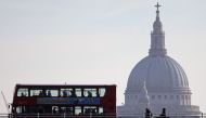 Commuters cross Waterloo Bridge in London bus and on foot as they cross the River Thames and make their way into the City of London, on March 21, 2018, backdropped by the dome of St Paul's Cathedral.  AFP / Daniel Leal-Olivas