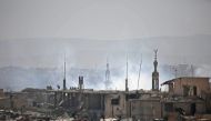 (FILE PHOTO) A picture taken on March 20, 2018 shows smoke plumes rising during regime bombardment in the rebel-held town of Arbin in the Eastern Ghouta enclave outside the capital Damascus. AFP / Amer ALMOHIBANY
