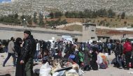 Syrian civilians and rebel fighters evacuated from Eastern Ghouta arrive in the village of Qalaat al-Madiq, some 45 kilometres northwest of the central city of Hama, on March 26, 2018, as evacuations from Eastern Ghouta continued following a deal that was