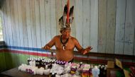 Chief Marcelino Apurina of the Aldeia Novo Paraiso in the Western Amazon region of Brazil near Labrea stands by a table of modern medicines delivered to the village on September 21, 2017. (AFP / Carl De Souza) 