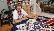 Royal superfan Donna Werner poses with some of the photos and memorabilia she has collected traveling to England for the weddings of Prince Andrew, Prince William and Queen Elizabeth's 90th birthday celebration, at her home in New Fairfield, Connecticut, 