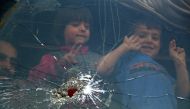 Children look out of the window of a bus upon their arrival at the Abu al-Zindeen checkpoint near the northern Syrian town of al-Bab after Jaish al-Islam fighters and their families from the former rebel bastion's main town of Douma were evacuated from th