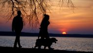 People with a dog enjoy sunset at a lake on the outskirts of Minsk, Belarus April 10, 2018. Reuters/Vasily Fedosenko