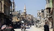 People walking down a street in the Eastern Ghouta town of Douma after Syrian government forces entered the last rebel bastion.  AFP / SANA 
