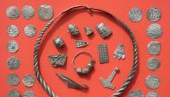 Parts of the silver treasure are pictured on a table in Schaprode, northern Germany on April 13, 2018. A 13-year-old boy and a hobby archaeologist have unearthed a 