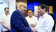 Philippine President Rodrigo Duterte (R) meeting Kuwaiti Ambassador to the Philippines Musaed Saleh Ahmad Althwaikh (L) at the presidential guest house in Davao City, in southern island of Mindanao, as Philippines' Foreign Secretary Alan Cayetano (back, L