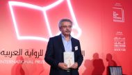 Palestinian writer Ibrahim Nasrallah poses for a photo after winning the 2018 International Prize for Arabic Fiction for his book titled 