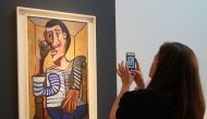 (FILES) In this file photo taken on May 3, 2018 a Christie's employee takes a picture of Pablo Picasso's 