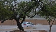 A picture taken on May 25, 2018, shows cars driving through a flooded street in the southern city of Salalah as the country prepares for landfall of Cyclone Mekunu. Heavy rains and strong winds pummelled Dhofar province, with an AFP photographer in Salala