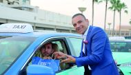 A staff of a Marriott Hotel in Qatar hands over Iftar kit to a cab driver. 