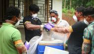 (FILES) In this file photo taken on May 21, 2018 Animal Husbandry department and Forest officials deposit a bat into a container after catching it inside a well at Changaroth in Kozhikode in the Indian state of Kerala. (AFP)