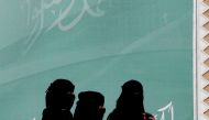 File photo of women walk past a poster on the outskirts of Riyadh, Saudi Arabia February 12, 2018. REUTERS/Faisal Al Nasser/File Photo