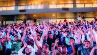 Football fans cheering at Khalifa International Stadium Fan Zone during a match. 