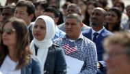 Immigrants look on before being sworn in as American citizens during a naturalization ceremony on the flight deck of the USS Hornet on July 3, 2018 in Alameda, California. 76 immigrants from 31 countries were sworn in as American citizens during a ceremon