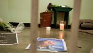 A candle burns in the former cell of Nelson Mandela during a visit of a group of activists, religious leaders and former prisoners (unseen) at Robben Island, Cape Town, for an all night vigil to commemorate Nelson Mandela, who was a prisoner on the island