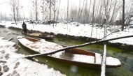 A Kashmiri farmer rows his boat on the Dal Lake during a heavy snowfall in Srinagar on January 25, 2017. (AFP / Tauseef Mustafa) 