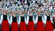 Choir singers and dancers wear traditional dress as they perform during the final show at the Song and Dance Celebration in Riga, Latvia July 8, 2018. Reuters/Ints Kalnins

