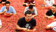 This photo taken on July 8, 2018 shows a contestant taking part in a chilli pepper-eating competition in Ningxiang in China's central Hunan province. The winner of the contest ate 50 chilli peppers in one minute. - China OUT / AFP 