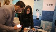 FILE PHOTO: Uber recruiter Lorena Castellanos, 26,  talks to jobseeker Masood Noori, 26, at TechFair LA a technology job fair in Los Angeles.  Reuters/Lucy Nicholson