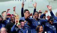 French goalkeeper Hugo Lloris holds the trophy as he celebrates with team-mates and icials upon their arrival at the Roissy-Charles de Gaulle airport in Paris yesterday, after winning the FIFA 2018 World Cup final.