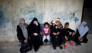 REPRESENTATIVE IMAGE: A Palestinian woman sits with a child after receiving food supplies from the UN offices in the Khan Yunis refugee camp in the southern Gaza Strip, on February 11, 2018. (AFP / Said Khatib) 