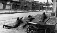 This photograph taken in 1989 shows Indian policemen taking positions after Kashmiri militants opened fire on government forces in the old city area of Naid Kadal in Srinagar.  AFP / Habib Naqash