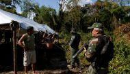  Agents of the Brazilian Institute for the Environment and Renewable Natural Resources, or Ibama, check a man at an illegal logging camp during 