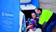 This photo taken on July 24, 2018 shows workers collecting clothing from a bin belonging to the St Vincent de Paul Society, a major charity recycling clothes, in Sydney. AFP / Peter Parks