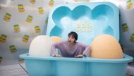 In this picture taken on August 31, 2018, a visitor poses for a photograph at the Egg House in Shanghai. / AFP / Johannes EISELE