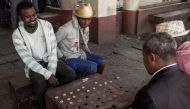 Jean-Marie Andriatsarafara (R), known as Zamabe, 30-years-old, a player of Fanorona since the age of 11 years and champion of Madagascar since 2016, plays a game of Fanorona in the capital Antananarivo on June 20, 2018.  AFP / RIJASOLO