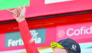 Mitchelton-Scott's British cyclist Simon Philip Yates celebrates on the podium retaining the general rank leader's Red Jersey after the 19th stage of the 73rd edition of 