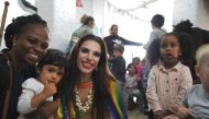 Drag performer Topsy Redfern poses for a photo with members of staff and children at London Early Years Foundation nursery in London, United Kingdom on August 24, 2018. Thomson Reuters Foundation / Cormac O'Brien