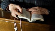 A believer reads the bible during mass at St. Joseph's Church, a government-sanctioned Catholic church, in Beijing, China, October 1, 2018. Reuters/Thomas Peter